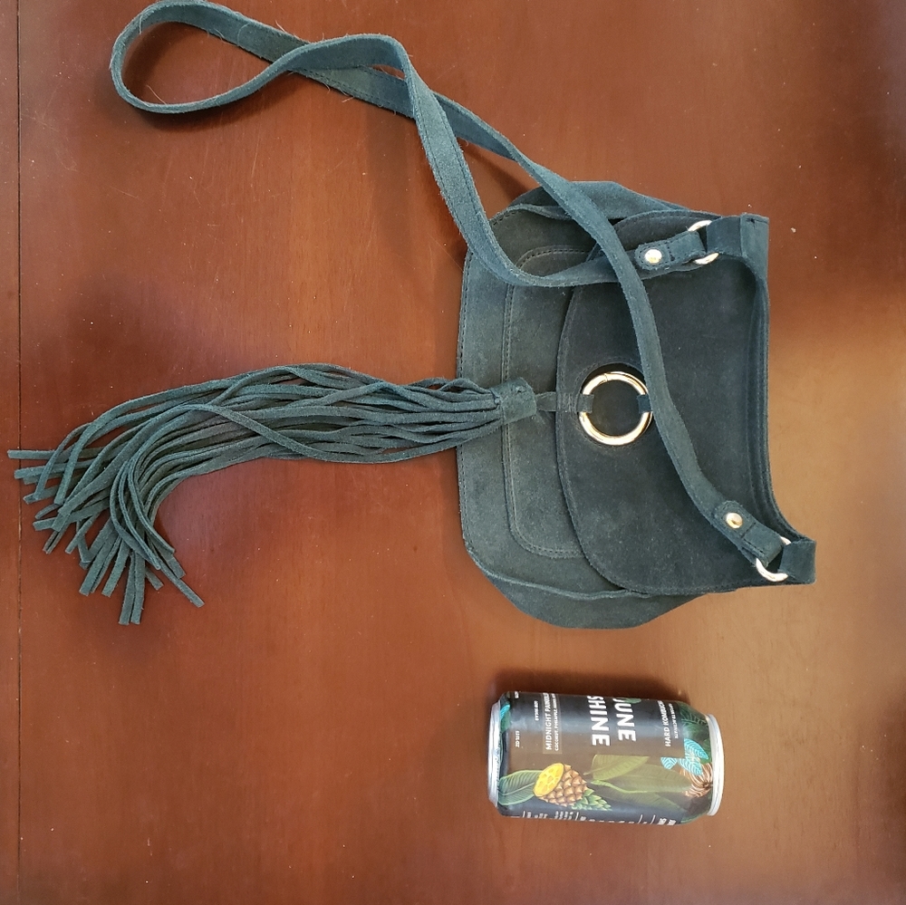 green suede saddle crossbody bag with tassle enclosure